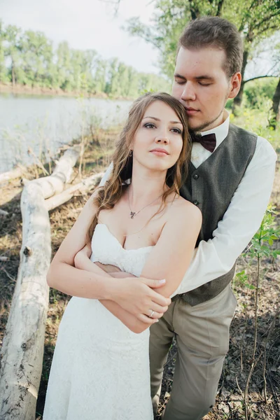 Sposa e sposo braccio in piedi contro i laghi erba sfondo — Foto Stock