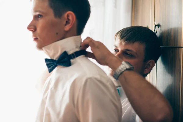 Friend of the bridegroom helps him to wear a bow tie — Stock Photo, Image