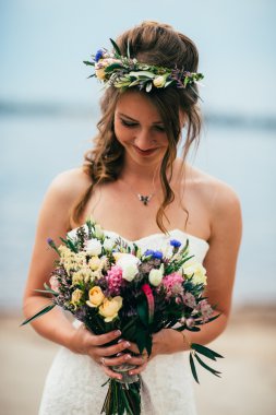 bir buket çiçek nehir üzerinde arka plan ayakta ile genç gelin