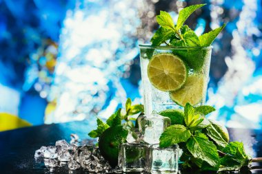 mojito limon ve nane buz küp yakın çekim kırmızı saman ile mavi arka plan üzerinde bardak
