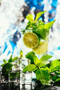 mojito limon ve nane buz küp yakın çekim kırmızı saman ile mavi arka plan üzerinde bardak