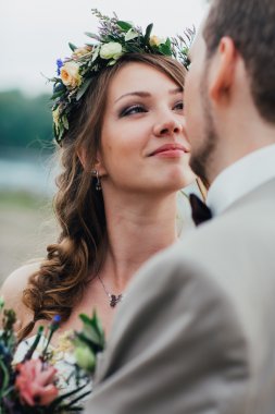 Genç damat ve gelin ayakta nehrin arka plan üzerinde sarılma.