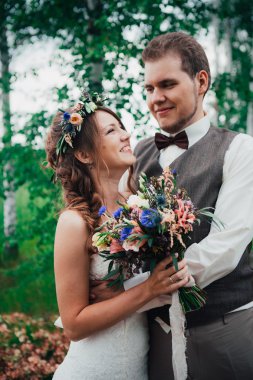 Gelin ve damat yaprakları orman arka plan üzerinde sarılma