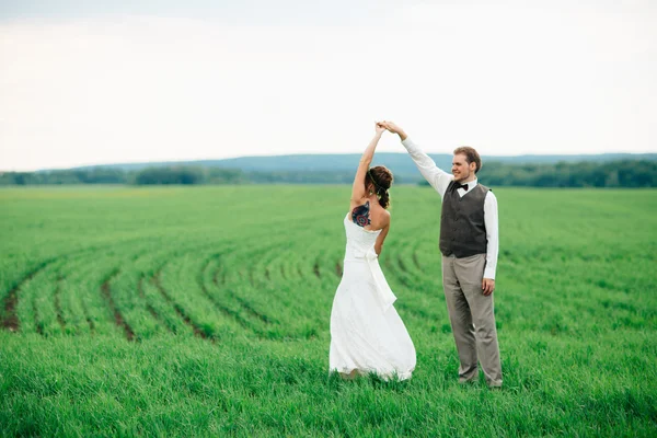 Braut und Bräutigam mit einem Strauß auf der grünen Wiese — Stockfoto