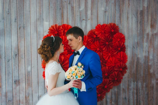 Молодий наречений цілує наречену в інтер'єрі студії — стокове фото