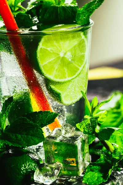 Vidro de mojito com limão e cubo de gelo de hortelã close-up palha vermelha — Fotografia de Stock