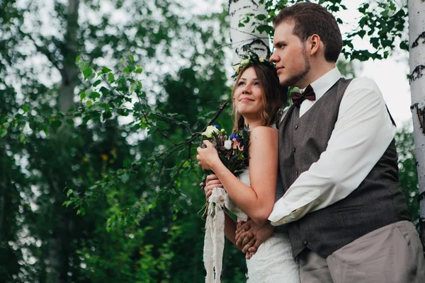 Portrait d'une mariée et marié embrasser sur fond feuilles forêt — Photo