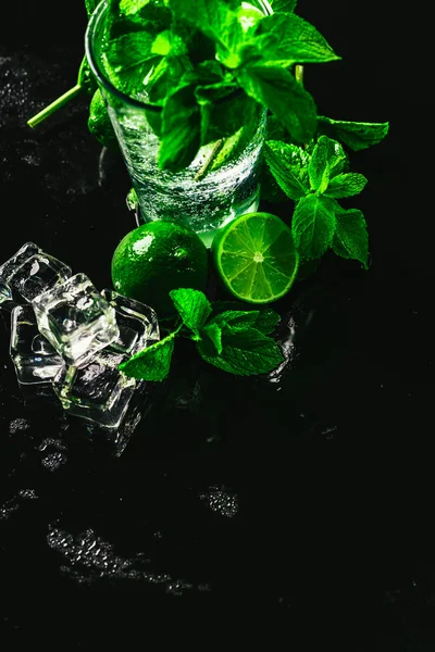 Стакан мохито с лаймом и мятным кубиком льда крупным планом на темном фоне — стоковое фото
