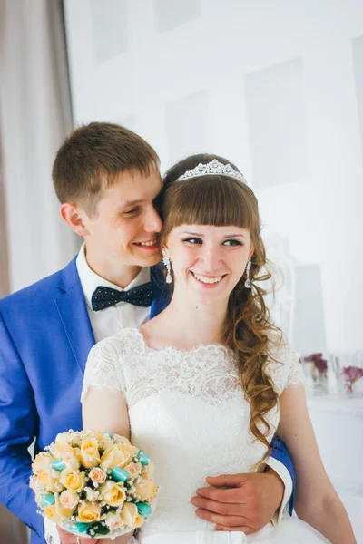 Jovem noivo beijando a noiva em um estúdio interior — Fotografia de Stock