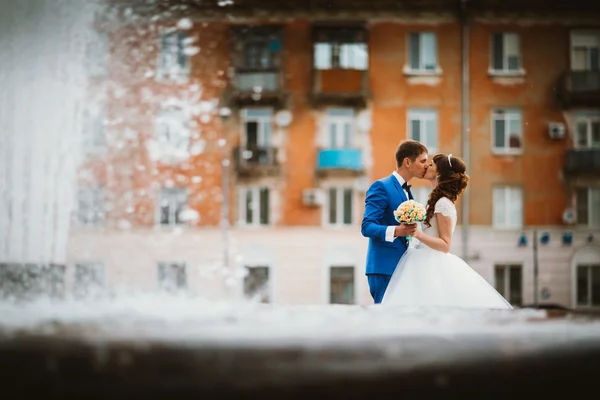 Nevěsta a ženich v blízkosti kašny v létě — Stock fotografie