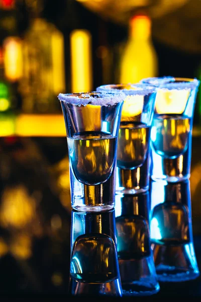 Stack of tequila with salt close up on blurred background — Stock Photo, Image