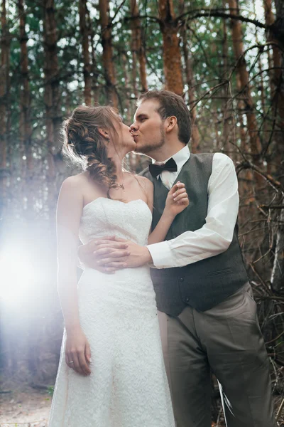 Drámai képet menyasszony és a vőlegény, a háttérben a levelek erdő háttérvilágítás — Stock Fotó