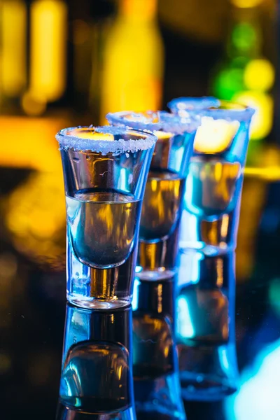 Stack of tequila with salt close up on blurred background — Stock Photo, Image