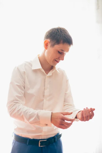 Young groom stands on the background of a window — Stock Photo, Image