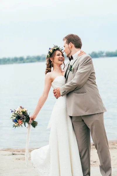 Jeune marié et mariée debout étreinte sur le fond de la rivière — Photo