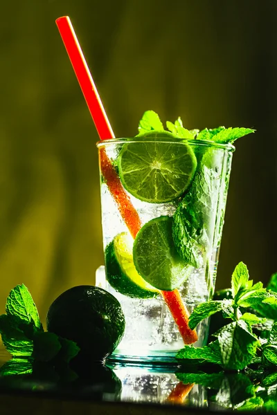 Vidro de mojito com limão e cubo de gelo de hortelã close-up palha vermelha — Fotografia de Stock