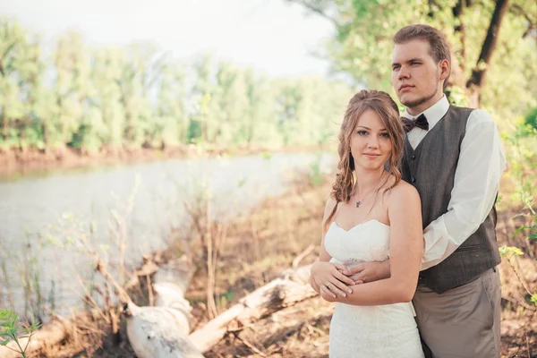 Menyasszony és a vőlegény, állandó a háttérben a fű tavak — Stock Fotó