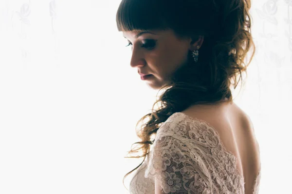 Portrait of a young bride standing near  window — Stock Photo, Image