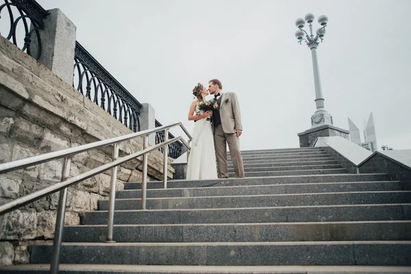 Young bride and groom on the background of the stairs — Stock Photo, Image