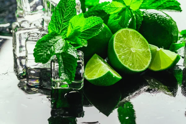 Menthe verte fraîche et glaçon citron vert en gros plan sur un fond sombre — Photo