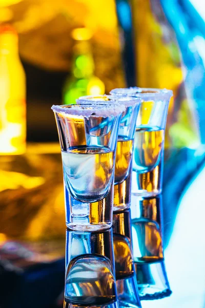 Stack of tequila with salt close up on blurred background — Stock Photo, Image