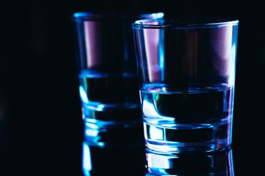 Karanlık bir arka planda yakın plan içki bardakları.