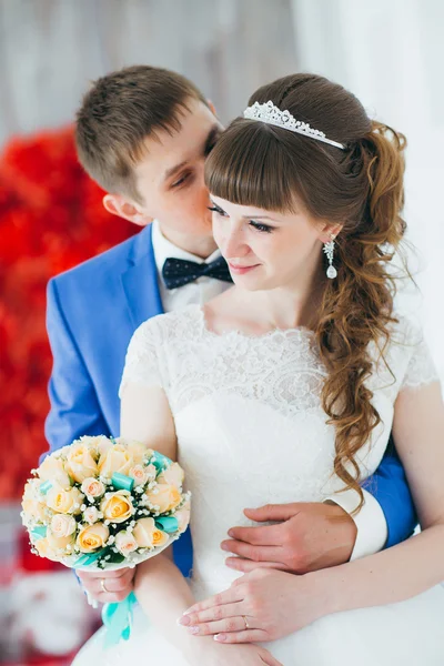 Jeune marié embrasser la mariée dans un studio intérieur — Photo