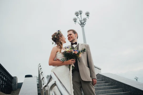 Young bride and groom on the background of the stairs — Stock Photo, Image