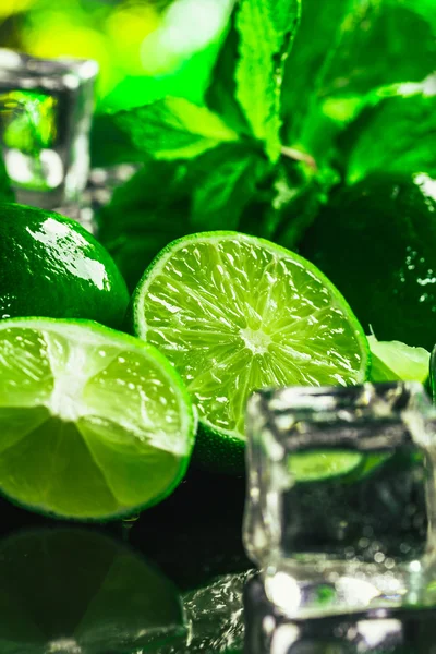 Hortelã verde fresca e cubo de gelo de limão close-up em um fundo escuro — Fotografia de Stock