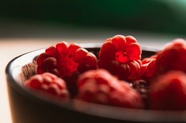 Ahududu ahşap plakalar üzerinde arka plan bulanık bir fincan