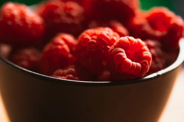 Raspberry in a cup on  blurred background of wooden planks — Stock Photo, Image