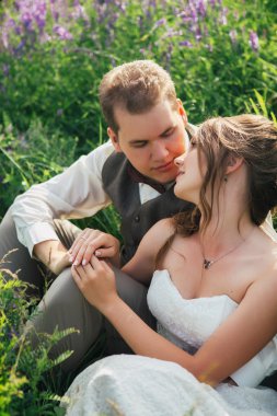 Gelin ve damat bir lavanta arka plan üzerinde dinlenme portresi