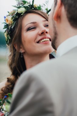 Genç damat ve gelin ayakta nehrin arka plan üzerinde sarılma.