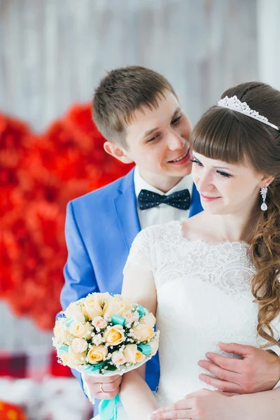 Junger Bräutigam küsst die Braut im Studio — Stockfoto