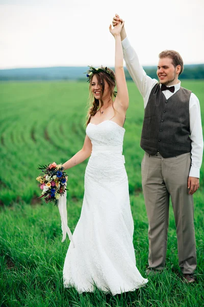 Nevěsta a ženich s kyticí na zelené louce — Stock fotografie