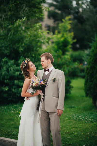 Молодой счастливый жених и невеста на фоне зелени — стоковое фото