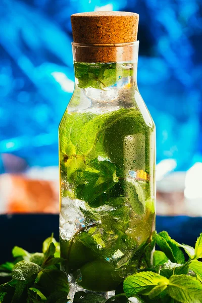 Mojito flaska med lime och mint ice cube närbild på blå bakgrund — Stockfoto