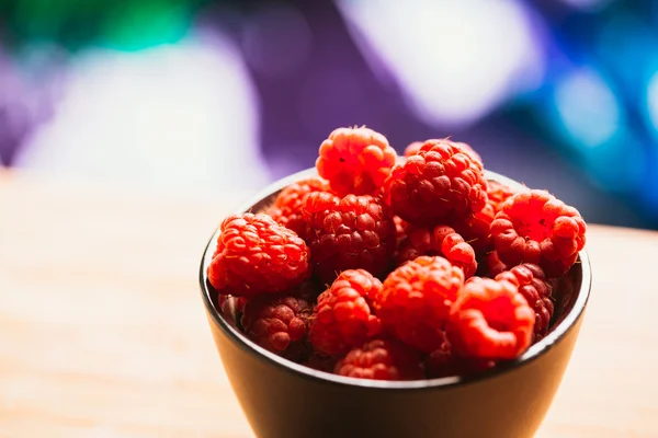 Raspberry in a cup on  blurred background of wooden planks — Stock Photo, Image