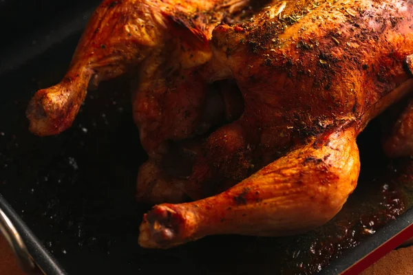Pollo recién horneado con una corteza rojiza en la sartén oscura — Foto de Stock