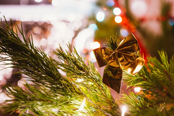 Arco dourado em um fundo de ramos de árvore de Natal verdes — Fotografia de Stock