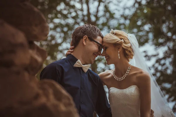 Mooie jonge bruid en bruidegom in een park — Stockfoto