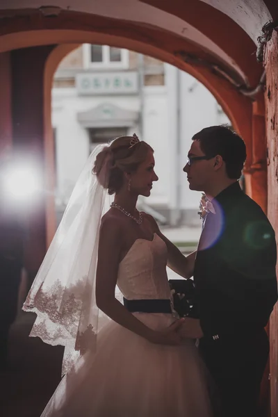 Retrato de close-up de noiva e noivo beijando em túnel antigo feito de tijolos — Fotografia de Stock