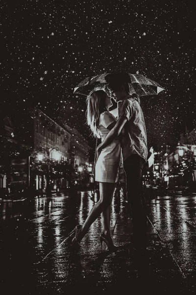 Gelukkige paar kussen onder de regen — Stockfoto