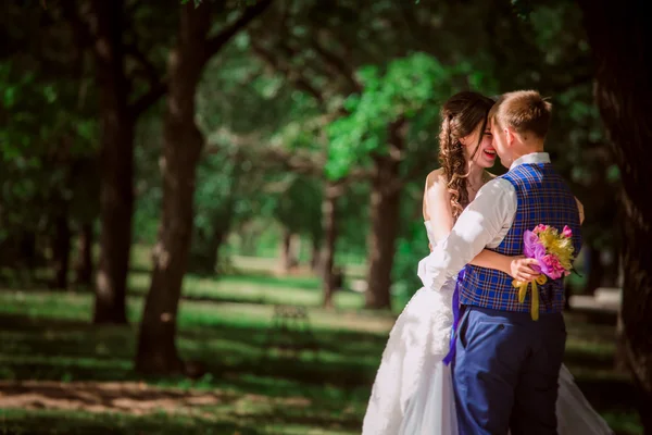 O casal recém-casado de pé no parque — Fotografia de Stock