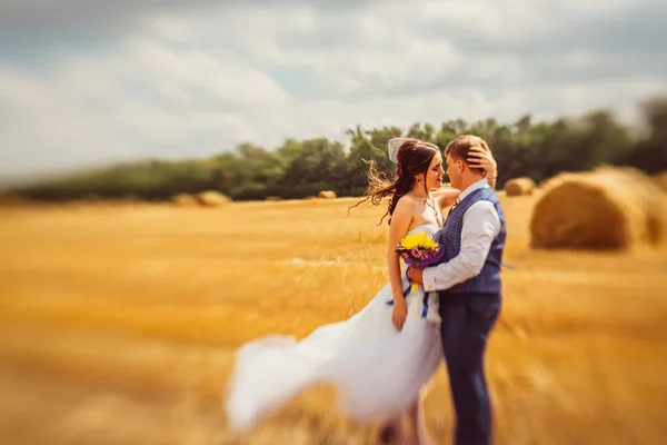 Nevěsta a ženich se závojem poblíž seno — Stock fotografie