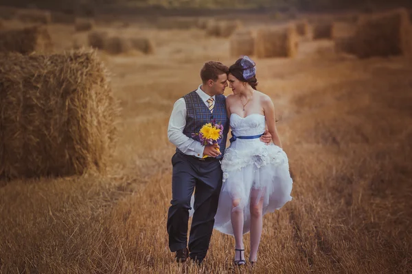 Nevěsta a ženich se závojem poblíž seno — Stock fotografie