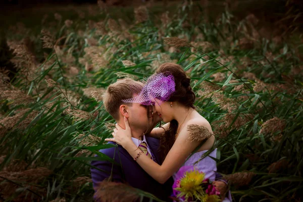 Jovem casal nupcial atraente de mãos dadas ao ar livre ao lado de árvore por lago — Fotografia de Stock