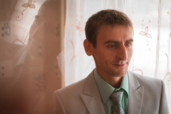 Portrait of young groom tying tie while getting ready for wedding — Stock Photo, Image