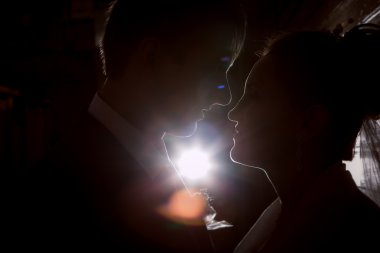 Siluetleri koyu arka planda bir güzel düğün çift. Retro veya vintage tarzı.