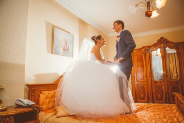 Gelin ve damat otel yatak üzerinde eğleniyor